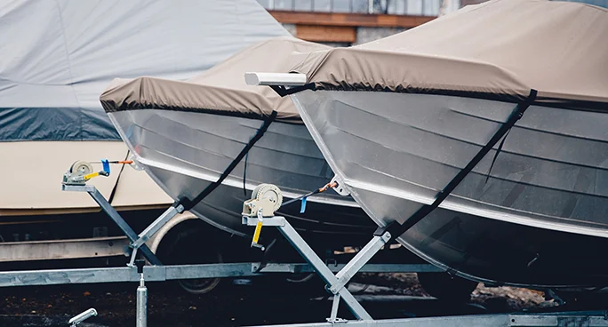 Covered boats on trailers prepared for seasonal storage